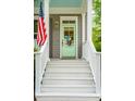 Inviting front porch stairs leading to a charming light green door, adorned with an American flag at 1629 Ware Bottom Ln, Mount Pleasant, SC 29464