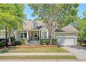Inviting home with well-maintained landscaping, a front porch, and a two-car garage at 1678 William Hapton Way, Mount Pleasant, SC 29466