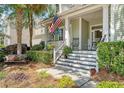 This home has a charming front porch with rocking chairs and an American flag displayed at 1678 William Hapton Way, Mount Pleasant, SC 29466
