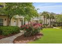 Inviting two-story home featuring a pergola, tidy landscaping, and beautiful pink roses along the walkway at 1825 Brittlebush Ln, Johns Island, SC 29455