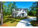 Beautiful two-story home with a charming exterior and a winding driveway through lush greenery at 202 Countryside Way, Summerville, SC 29483
