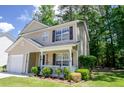 Charming two-story home featuring a well-kept lawn, attached garage, and welcoming front porch at 206 Trickle Dr, Summerville, SC 29483