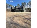 View of a stately green home with a dark roof and chimney surrounded by tall trees at 2151 River Road, Johns Island, SC 29455