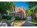 Charming two-story home with a double porch, landscaped yard, and detached garage with a brick driveway at 2324 High Tide Dr, Charleston, SC 29414