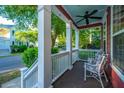 Inviting front porch with rocking chairs and a ceiling fan, perfect for relaxing and enjoying the outdoors at 2324 High Tide Dr, Charleston, SC 29414