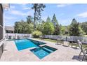 Backyard with a sparkling pool and hot tub alongside a spacious tiled patio and a white fence at 2827 Wagner Way, Mount Pleasant, SC 29466