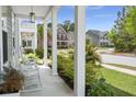 Inviting front porch features white columns and views of a beautifully landscaped yard at 3191 Moonlight Dr, Charleston, SC 29414