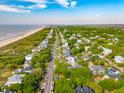 Expansive aerial view of a coastal community with lush greenery, pristine beach, and a clear blue ocean at 3301 Palm Blvd, Isle of Palms, SC 29451