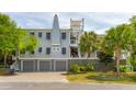 Charming three-story home with a three-car garage, multiple balconies, and lush tropical landscaping at 3301 Palm Blvd, Isle of Palms, SC 29451
