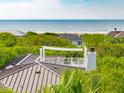 Scenic view of the ocean over lush greenery from the rooftop balcony of a beautiful home at 3301 Palm Blvd, Isle of Palms, SC 29451