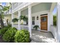 Welcoming front porch with ferns, fresh landscaping, stained wood door, and blue ceiling providing southern charm at 404 Forsythia Ave, Summerville, SC 29483
