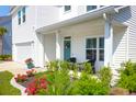 Inviting front porch with outdoor seating, colorful flowerbeds, and a charming wreath on the teal-colored front door at 408 Trevi Ln, Summerville, SC 29486