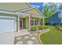 Inviting front entrance with a well-manicured lawn, charming walkway, and a cozy front porch at 409 Carousel Ct, Summerville, SC 29483