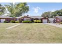 Spacious brick home with a well-manicured lawn, driveway, and a detached garage at 5029 Victoria Ave, North Charleston, SC 29405