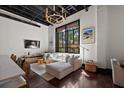Bright living room with natural light, exposed ceiling, hardwood floors, and modern decor at 517 King St # 13, Charleston, SC 29403