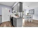 Open kitchen with modern gray cabinets, granite countertops, and stainless steel appliances at 5737 Dewsbury Ln, North Charleston, SC 29418