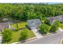 Aerial view of home and backyard, showcasing pond views and mature trees at 606 Knowledge Dr, Ladson, SC 29456