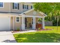 Inviting front porch with seating area, plants, and a well-kept lawn at 606 Knowledge Dr, Ladson, SC 29456