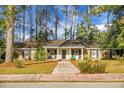 Classic brick home with a welcoming front porch and mature landscaping, offering a serene and inviting curb appeal at 702 Minus St, Saint George, SC 29477