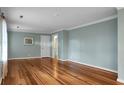 Spacious living room featuring refinished hardwood floors, fresh paint, crown molding, and ample natural light at 702 Minus St, Saint George, SC 29477