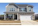 Charming two-story home boasts stone accents, a two-car garage, and a welcoming front porch with seating at 705 Squire Pope Rd, Summerville, SC 29486