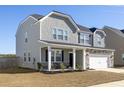 Attractive home featuring a covered porch, a two-car garage, and well-maintained landscaping at 705 Squire Pope Rd, Summerville, SC 29486