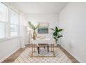 Bright office space featuring a sleek white desk, stylish rug, and ample natural light from the large window at 705 Squire Pope Rd, Summerville, SC 29486