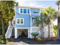 Charming coastal home with a light blue exterior, white trim, and multiple outdoor staircases to upper levels at 73 Fairway Dunes Ln, Isle of Palms, SC 29451