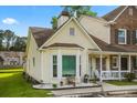 Eye-level shot of a yellow home with a bay window and landscaping at 801 Reserve Way, Summerville, SC 29485