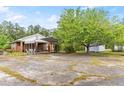 View of the backyard with a covered carport, outbuilding and a large shade tree at 9995 Lodge Hwy, Lodge, SC 29082