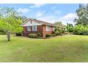 Side view of a brick house with a well-maintained lawn and charming blue shutters at 9995 Lodge Hwy, Lodge, SC 29082