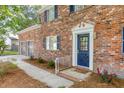Inviting brick home showcasing a charming blue front door with decorative trim and a manicured garden bed at 103 Sylvan Ter, Summerville, SC 29485