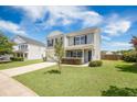Inviting two-story home with a well-kept lawn, long driveway, and a cozy front porch in a Gathering-friendly neighborhood at 1130 Moss Grove Dr, Moncks Corner, SC 29461