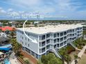 Multi-story condo showcases a corner unit with an ocean view, set amidst lush tropical landscaping on a clear day at 1140 Ocean Blvd # 201, Isle of Palms, SC 29451