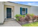 Close-up of the front entry featuring a nice garden, storm door and welcoming curb appeal at 121 Keaton Brook Dr, Summerville, SC 29485
