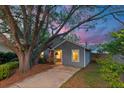 Twilight view of a gray home with a well-lit front porch and lush landscaping at 1224 Decoy Ct, Mount Pleasant, SC 29464