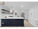 Modern white kitchen features dark island, stainless steel appliances, and open shelving at 1228 Penny Cir, Mount Pleasant, SC 29464