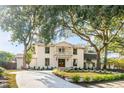 Charming two-story white home with a balcony, surrounded by mature trees and a well-manicured lawn at 19 Ponce De Leon Ave, Charleston, SC 29407