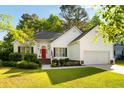 Lovely home with a green lawn, mature trees, and a red door, creating a welcoming curb appeal at 1971 N Smokerise Way, Mount Pleasant, SC 29466