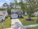 Two-story home with a long driveway, a two-car garage, and a large yard in a wooded community at 2016 Elvington Rd, Johns Island, SC 29455