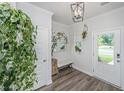 Bright foyer with modern decor, light wood floors, a bench, and a stylish light fixture at 203 O'Malley Dr, Summerville, SC 29483