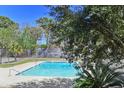 Refreshing community swimming pool featuring clear blue water, concrete surroundings, and partial tree coverage at 2030 Coldspring Dr # 708, North Charleston, SC 29406