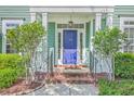Close-up of front entrance featuring a blue door, brick steps, and trimmed bushes at 219 Silverwood Ln, Summerville, SC 29485