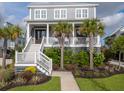 Attractive home with palm trees, manicured landscaping, and a welcoming front porch with seating at 2522 Waverly St, Charleston, SC 29492