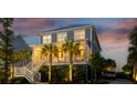 Beautiful two-story home featuring a metal roof, and a welcoming front porch at dusk at 2522 Waverly St, Charleston, SC 29492