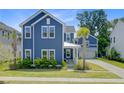 Two-story home with blue siding, manicured lawn, a cozy porch, and a convenient attached garage at 2557 Hatch Dr, Johns Island, SC 29455
