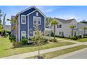 Beautiful two-story home with a charming blue exterior, complemented by lush landscaping and a sidewalk at 2557 Hatch Dr, Johns Island, SC 29455