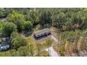 Aerial shot of a secluded single-story home surrounded by lush greenery and a gravel driveway at 314 Hickory Nut Way, Cross, SC 29436