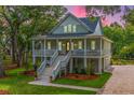 Beautiful two-story home featuring a spacious porch, lush greenery, and inviting curb appeal at 3635 Pandora Dr, Mount Pleasant, SC 29466