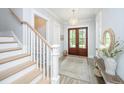 Inviting foyer featuring a staircase, wood floors, a stylish rug, and an elegant light fixture at 3635 Pandora Dr, Mount Pleasant, SC 29466